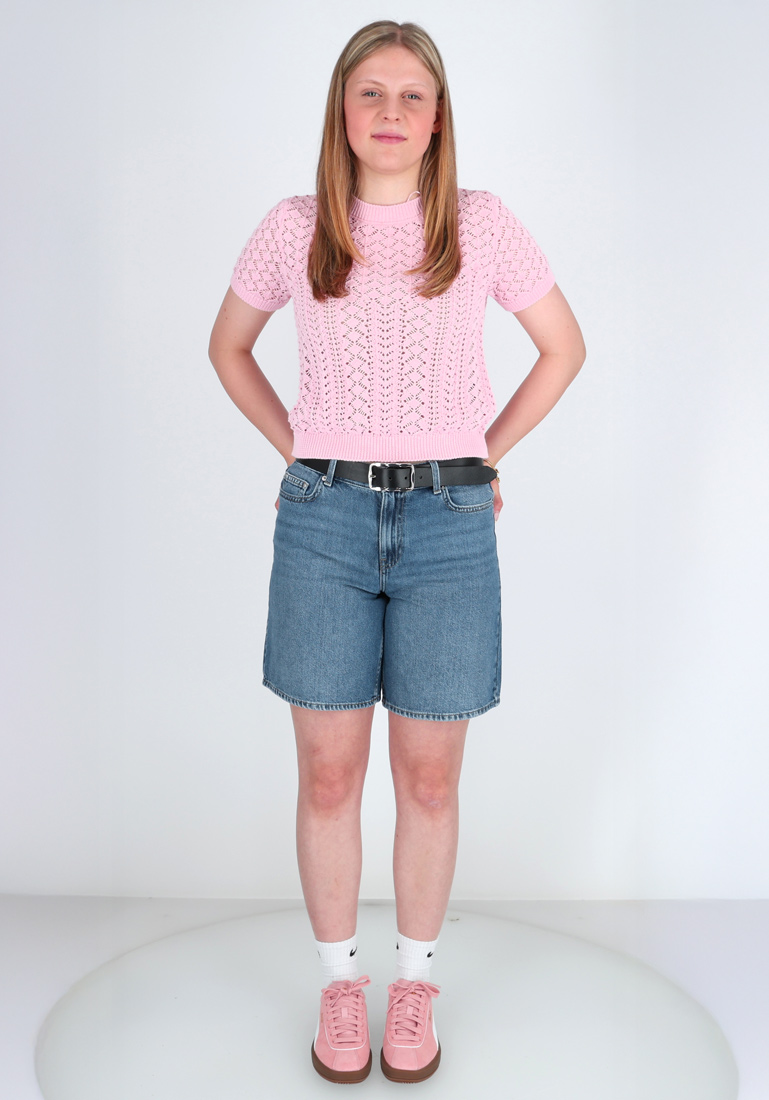 Frau in Denim-Shorts und rosa Oberteil