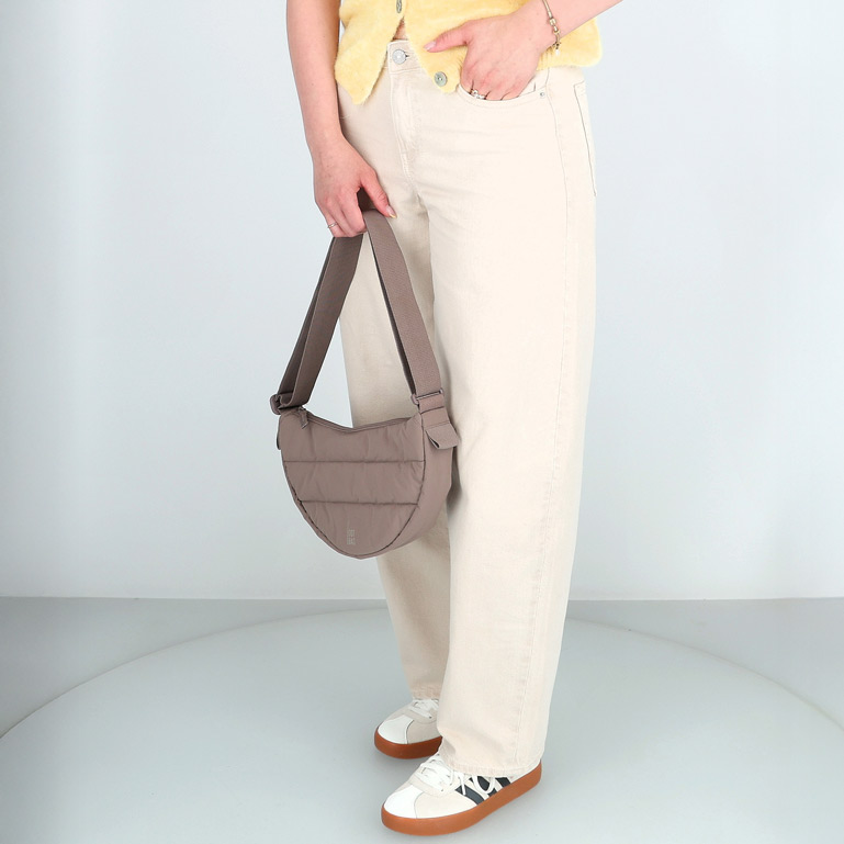 Frau mit beiger Jeans und brauner Tasche