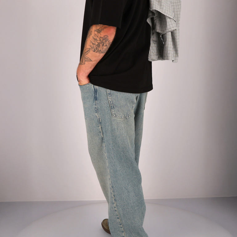 Ein Mann in einer blauen Jeans und einem schwarzen T-Shirt
