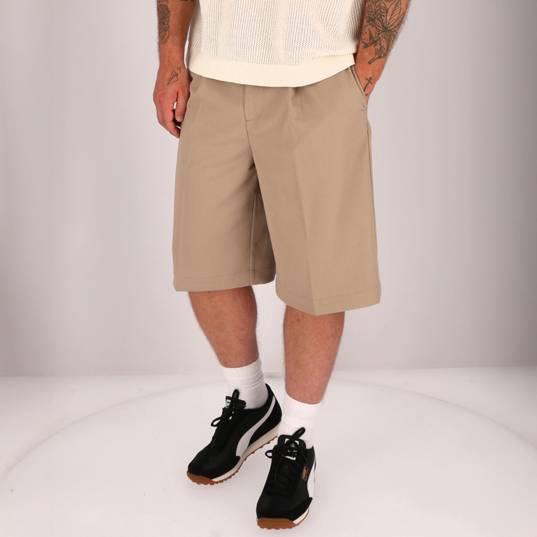 Mann mit beigen Shorts und schwarzen Sneakers