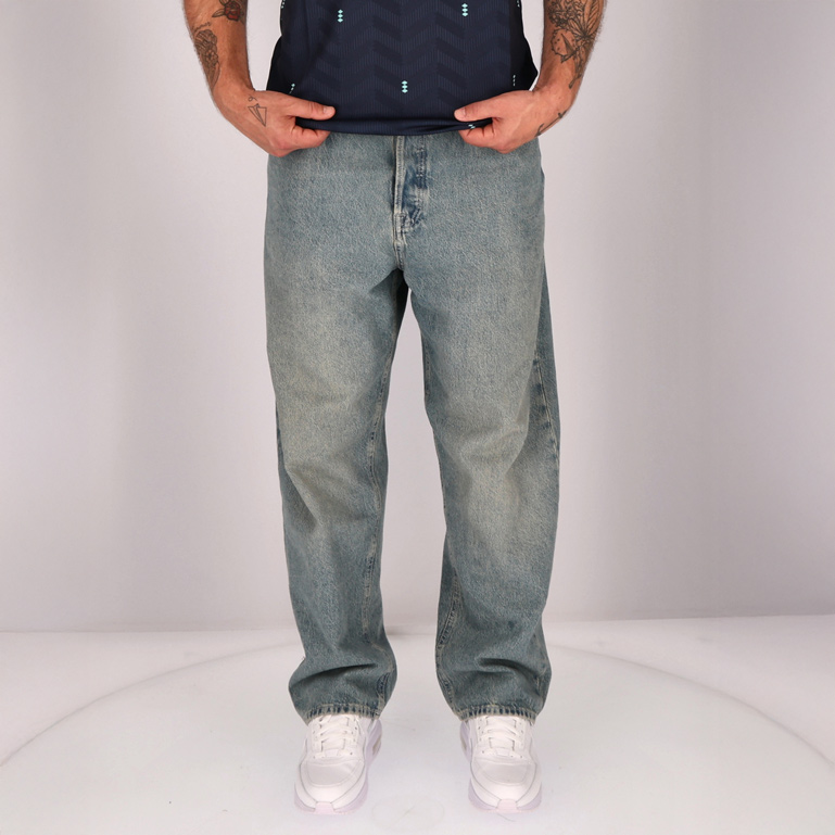 Ein Mann in blauer Jeans und weißen Sneakers