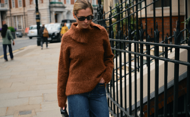 Frau mit floraler Bluse und hellblauer Blousonjacke
