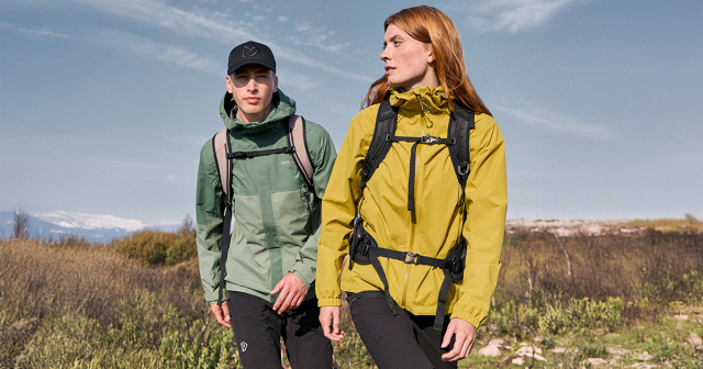 Frau und Mann in grüner Windjacke beim Wandern
