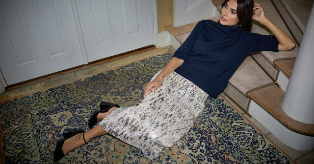 Frau in blauem Oberteil, Pailettenrock und schwarzen Pumps