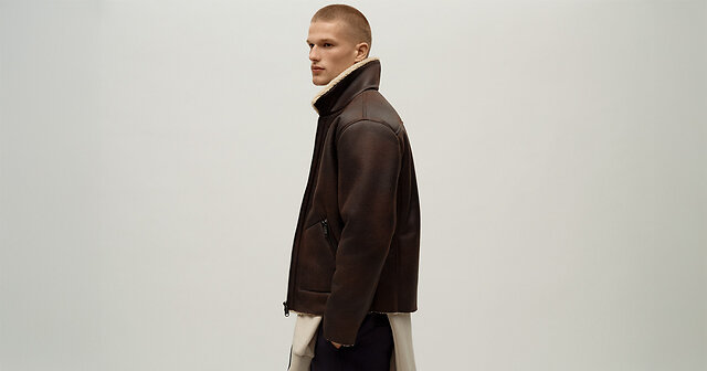 Mann steht seitlich in brauner Winterlederjacke