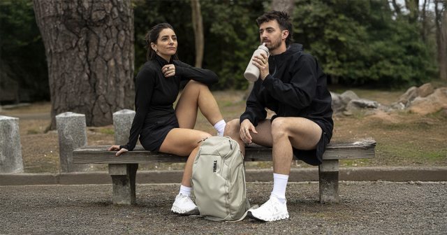 Mann und Frau sitzen auf einer Parkbank und machen eine sportliche Pause