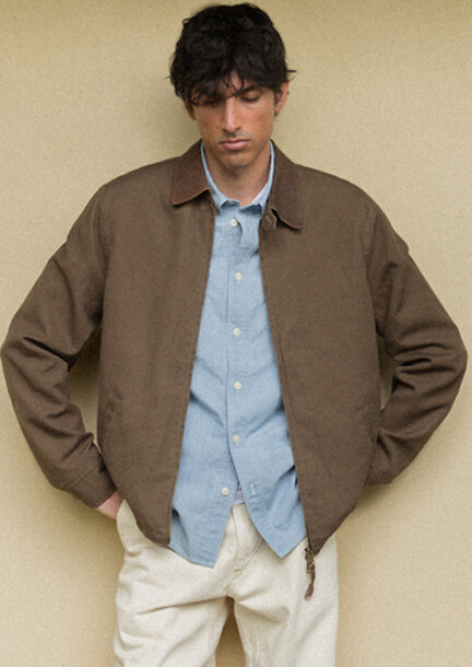 Mann mit brauner Jacke und blauem Hemd