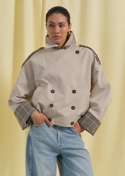 Frau im beigen. kurzen Trenchcoat