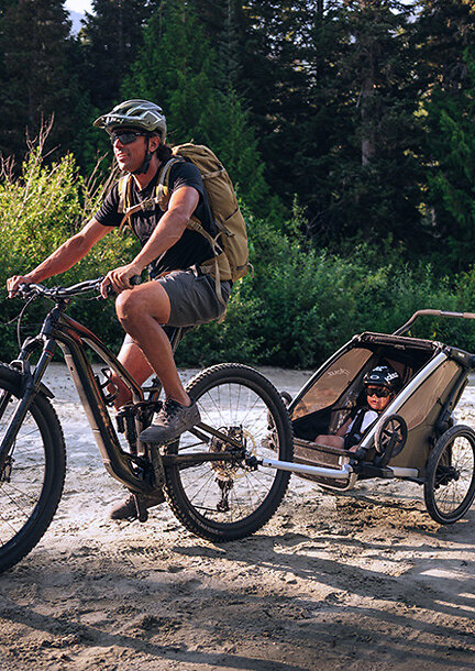 Mann auf dem Fahrrad mit Kinderanhänger