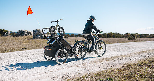 Person auf einem Bike mit Kinderfahrradanhänger