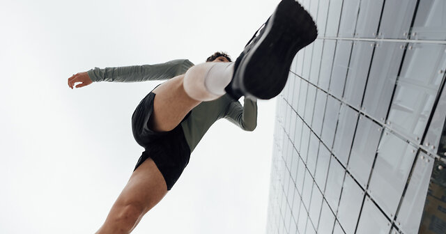 Frau springt beim Joggen mit Laufschuhen und Laufsocken