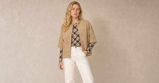 Frau mit hellbrauner Wildlederweste und kariertem Langarmshirt