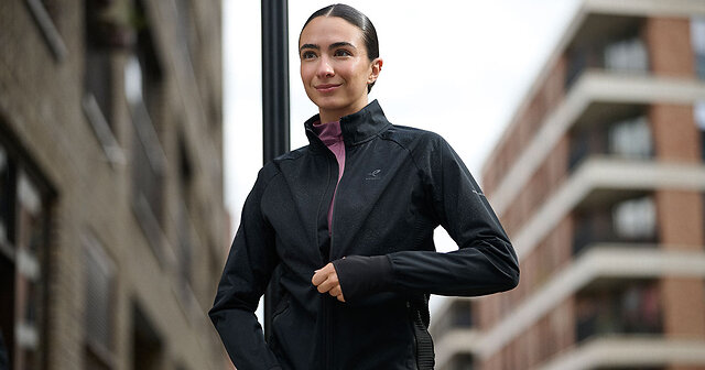 Läuferin schließt ihre Laufjacke zum Lauf