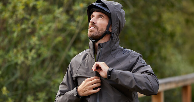 Mann mit wetterfester Jacke auf dem Fahrrad