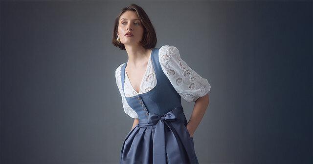 Frau mit blauem Dirndl und weißer Bluse
