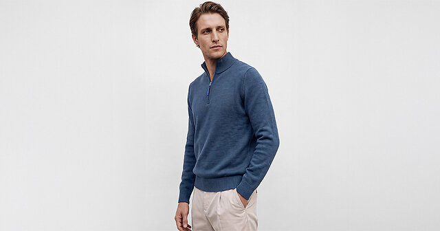Mann im blauen Zipper und beiger Hose